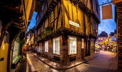 A Chirstmas night view of Shambles, a historic street in York featuring preserved medieval timber-framed buildings with jettied floors - obrazy, fototapety, plakaty