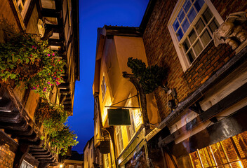 A Chirstmas night view of Shambles, a historic street in York featuring preserved medieval...