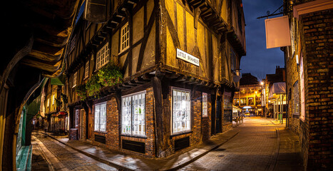 Fototapeta na wymiar A Chirstmas night view of Shambles, a historic street in York featuring preserved medieval timber-framed buildings with jettied floors