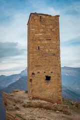 Tower of the abandoned village of Goor, Dagestan, Russia. Stone tower on the rocks and blue sky on the background