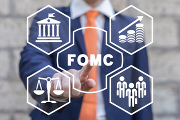 Businessman using virtual touchscreen presses abbreviation: FOMC. Government regulation. Finance...