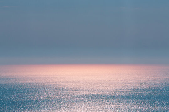 Abstract landscape. Blue background. Serene ocean water and pink sun light
