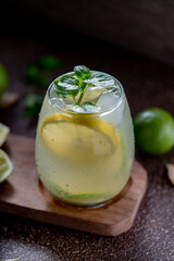close up of a glass glass with lime juice and a slice of lemon.