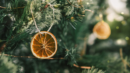 Rustic decorated ornament on Christmas tree with dried orange slices, sustainable Christmas decors concept