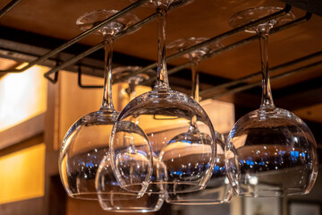 Fototapeta na wymiar Close up view of wine glasses hanging above a bar counter at a restaurant