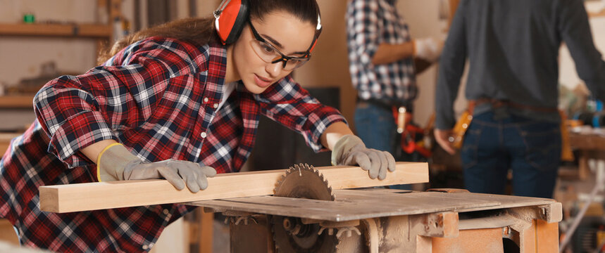 Professional carpenter working with sawmill machine in workshop. Banner design