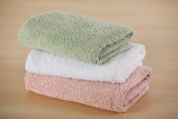 Stack of soft folded towels on wooden table