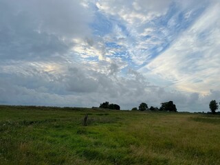 Picturesque view of green field and cloudy sky