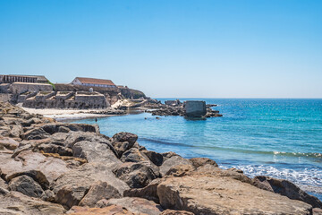 Selective focus in rocks with turquoise Atlantic Ocean and walls of the fort of the island of Las Palomas next to El Foso, Tarifa SPAIN