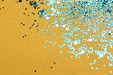 Shiny bright light blue glitter on yellow background. Space for text