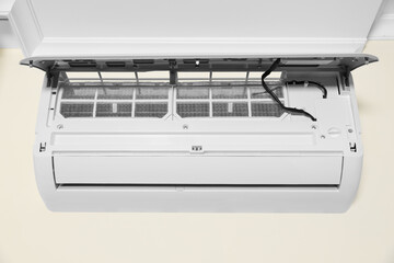 Modern air conditioner on white wall indoors