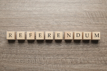 Word Referendum of cubes on wooden table, flat lay