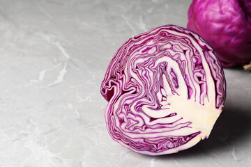 Half of fresh red cabbage on light grey marble table, space for text