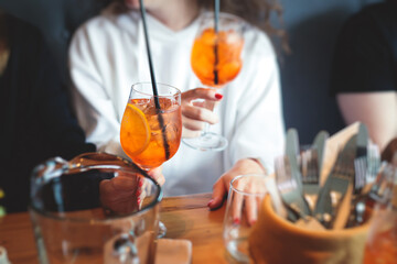 View of alcohol setting on catering banquet table, row line of orange red colored aperitif alcohol cocktails on a party, negroni, spritz and others on decorated catering bouquet table event