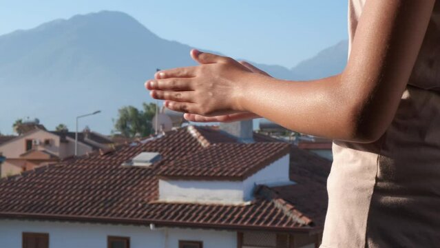 Clap your hands. Women's hands clap on the balcony.