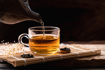 Hot tea in tea pot pouring in cup glass, Healthy drink