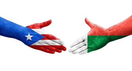 Handshake between Madagascar and Puerto Rico flags painted on hands, isolated transparent image.