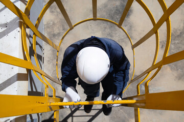 Male worker climbing vertical stairs..