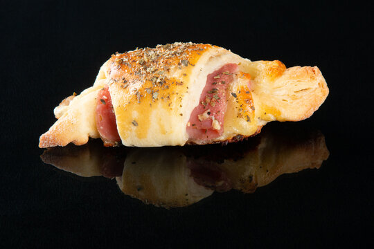 Croissant with cheese and ham. Black background
