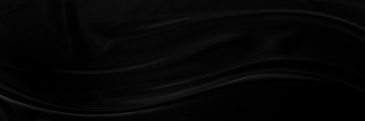 Black gray satin dark fabric texture luxurious shiny that is abstract silk cloth panorama background with patterns soft waves blur beautiful.