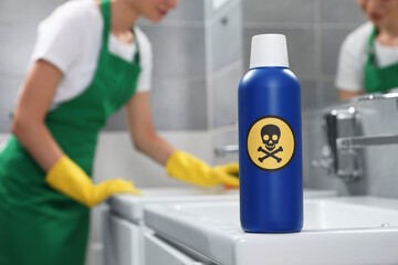 Obraz premium Bottle of toxic household chemical with warning sign in bathroom