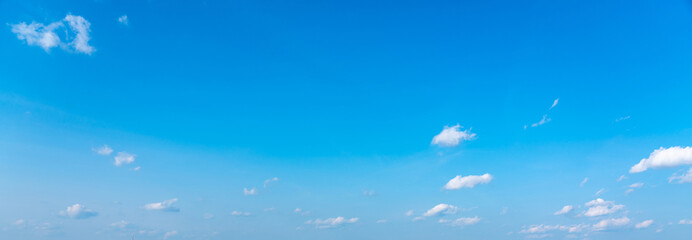 Fototapeta na wymiar Blue panoramic sky background with small white clouds
