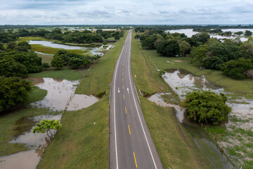 Highway in a rural landscape flooded by proximity to the Magdalena River in the department of Bolivar. Colombia .