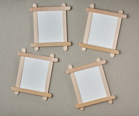 blank frame made of wooden ice cream sticks, empty photo or white background frame isolated on textured gray surface,copy space