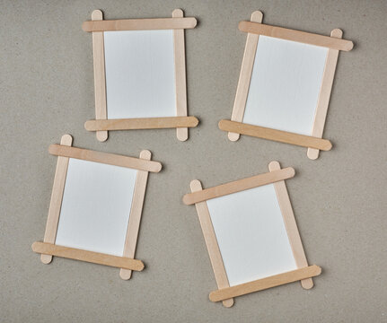 blank frame made of wooden ice cream sticks, empty photo or white background frame isolated on textured gray surface,copy space