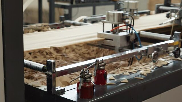 Automated fabric processing machinery operating at the production facility. Fabric processing machine cutting off the small pieces of textile. Factory machine processing the ecological beige material.
