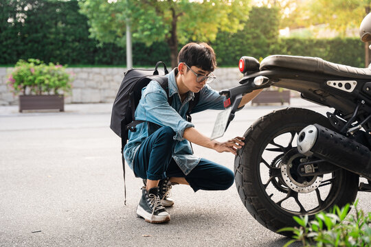 Young Asian man repairing motorbike