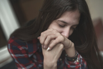 Helpless, hurt, depressed young woman feeling completely crushed, sitting outside on a cold day, grieving her fate