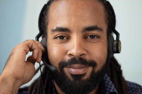  Close up face Happy businessman with headset interacting in his office looking to the camera 