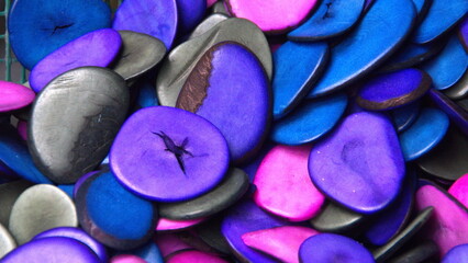 Obraz na płótnie Canvas Cut and polished tagua nuts, dyed cool colors, at a tagua nut jewelry shop in Iluman, Ecuador