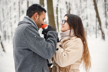 Portrait of a romantic couple spending time together in winter forest