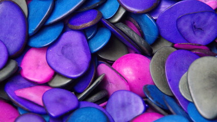 Cut and polished tagua nuts, dyed cool colors, at a tagua nut jewelry shop in Iluman, Ecuador