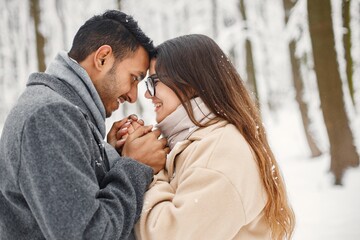 Portrait of a romantic couple spending time together in winter forest