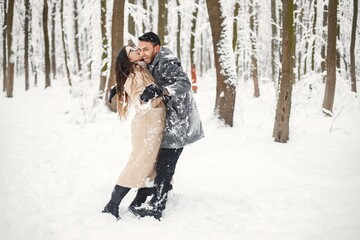 Portrait of a romantic couple spending time together in winter forest