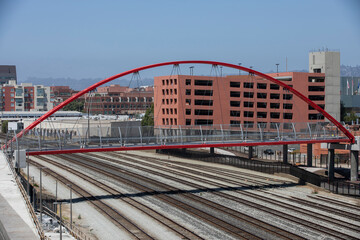 A bridge crosses train tracks in downtown Emeryville, California, USA. - obrazy, fototapety, plakaty