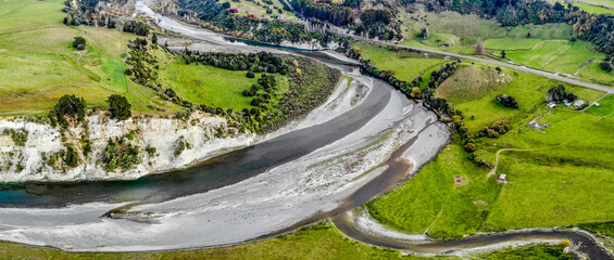 a panoramic aerial image of a river with white banks running through rural farmland in New Zealand