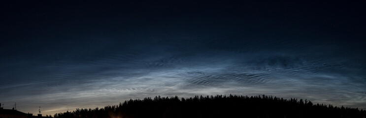 Noctilucent clouds, night shining clouds, are tenuous cloud-like phenomena in upper atmosphere of Earth, visible in northern hemisphere, most often in June July / summer nights. wide panoramic shot