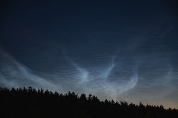 Naklejka na ściany i meble Noctilucent clouds, night shining clouds, are tenuous cloud-like phenomena in upper atmosphere of Earth, visible in northern hemisphere, most often in June July / summer nights. 