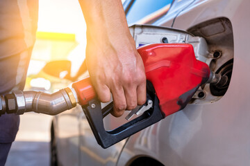 Closeup of a hand  man pumping petrol in car at refueling station - Transport and ownership concept.