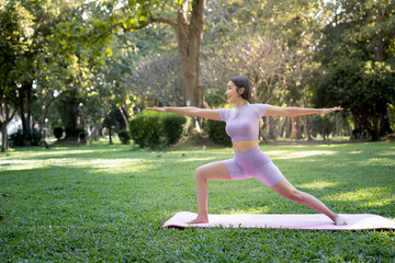 Portrait of a young woman doing yoga in the garden for a workout. Concept of lifestyle fitness and healthy. Asian women are practicing yoga in the park.