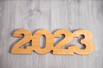 NEW year merry Christmas and happy holiday wooden numbers 2023 on a light wooden background eco-friendly general plan in light colors place for text