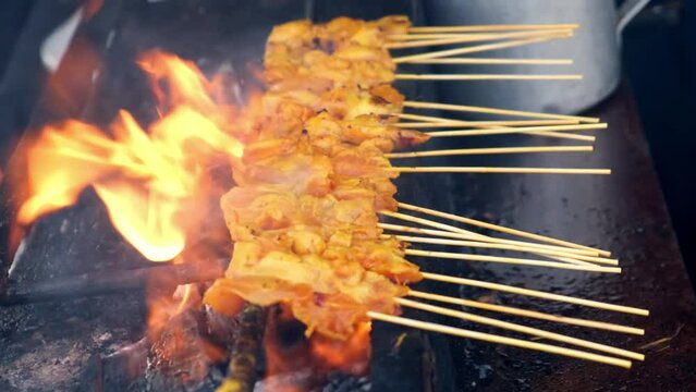 Vendor put the sauce on the satay chicken grilled food cooked