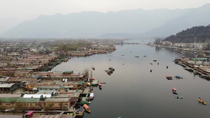 Aerial slow movement around cityscape Kashmir surrounded by Dal lake and buildings