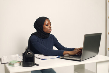Arabic entrepreneur working on a laptop in her office