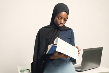 Arabic entrepreneur standing in her office looking some documents