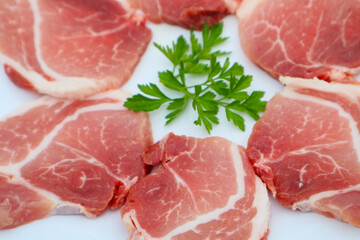Raw Pork Slice in White Round Plate decorated with parsley. Fresh raw pork.